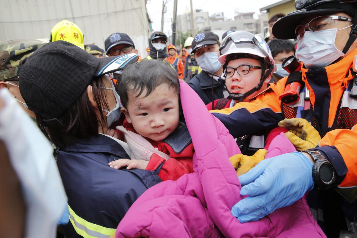 Rescatistas sacan a un niño de entre los escombros de un edificio que se vino abajo tras un sismo en Tainan, Taiwán. (Foto AP/Wally Santana)