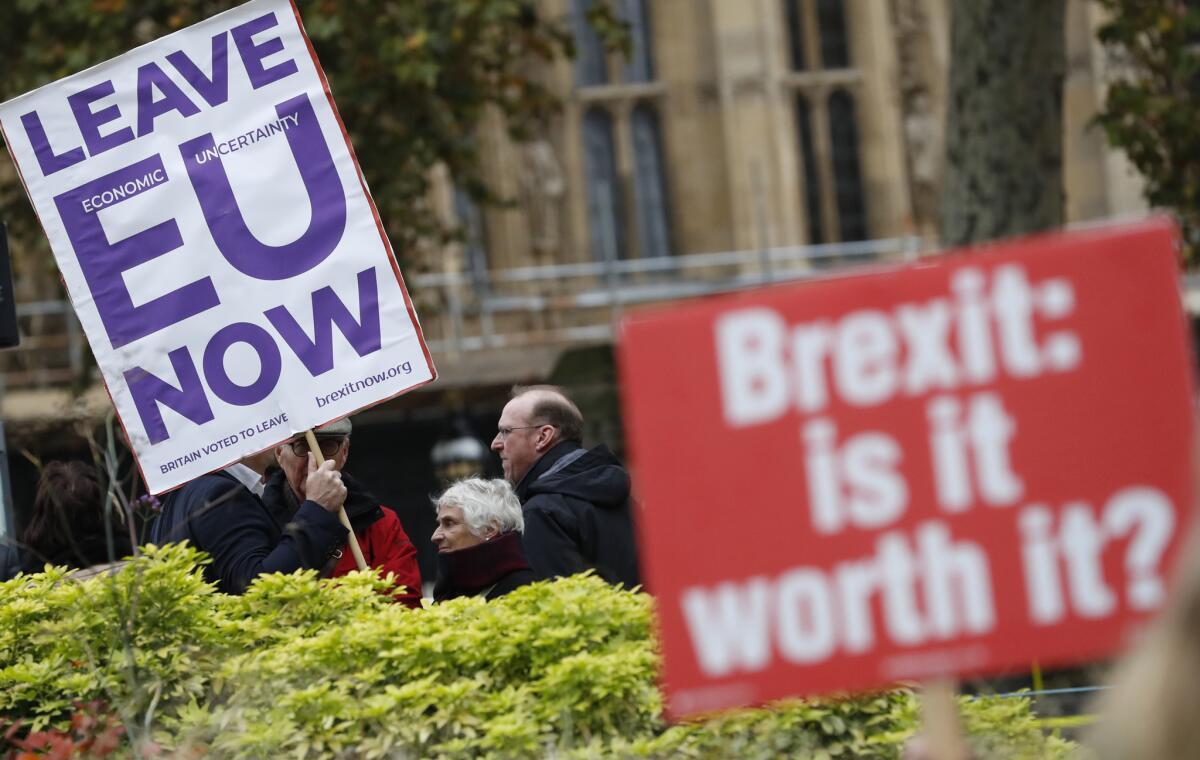Pro and antiBrexit protesters hold placards near Parliament in London in 2018.