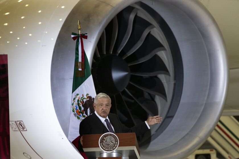 FILE - Mexican President Andres Manuel Lopez Obrador gives his daily, morning press conference in front of the former presidential plane at Benito Juarez International Airport in Mexico City, July 27, 2020. Obrador said Tuesday, Oct. 4, 2022 that his government is analyzing the creation of a state-owned, army-run airline that would fly 10 leased airplanes as well as the former presidential jet. (AP Photo/Marco Ugarte File)