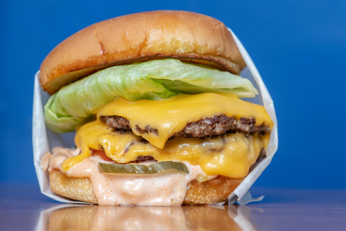 The Big Ben from Pie'n Burger features two cheese-covered patties, lettuce, pickle, tomato and sauce.