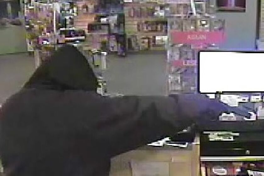 Authorities on Thursday released surveillance photos of a robber who allegedly fired a shot into a computer monitor on Feb. 21 at the Adult Depot on Pacific Highway.