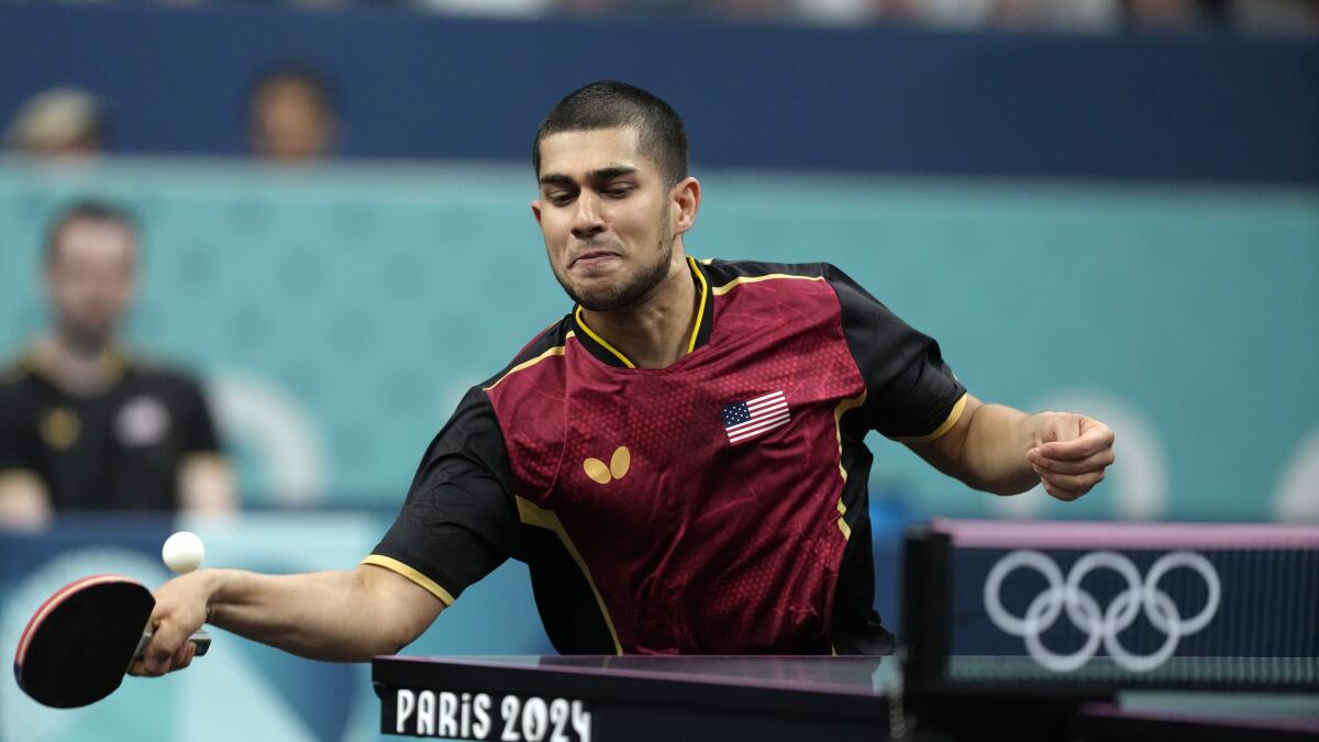 American Kanak Jha plays against Greece's Panagiotis Gionis during a men's singles round of 32 table tennis match