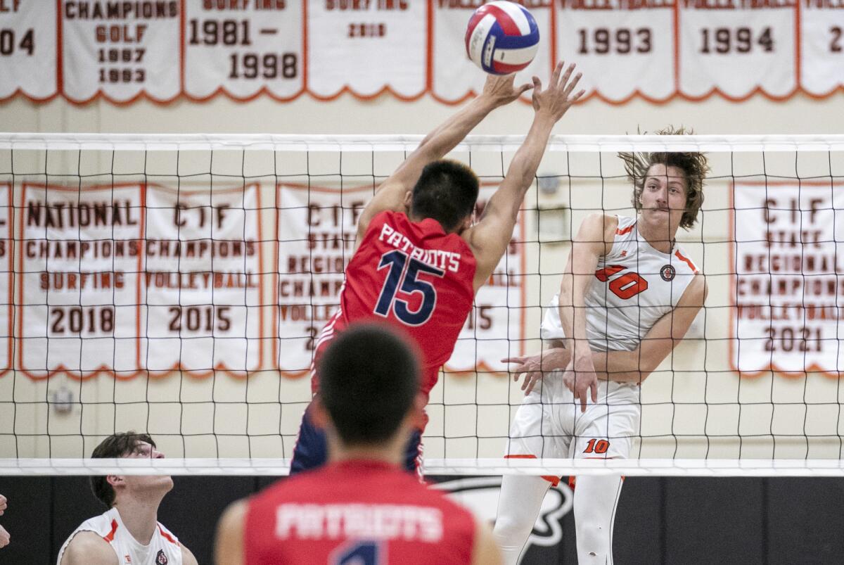 Huntington Beach's Liam Phinizy hits past Beckman's Noah Huang in a nonleague boys' volleyball match on Thursday.