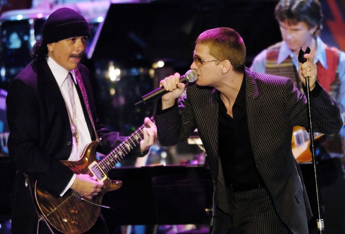 Latin guitarist Carlos Santana, left, performs with singer Rob Thomas.
