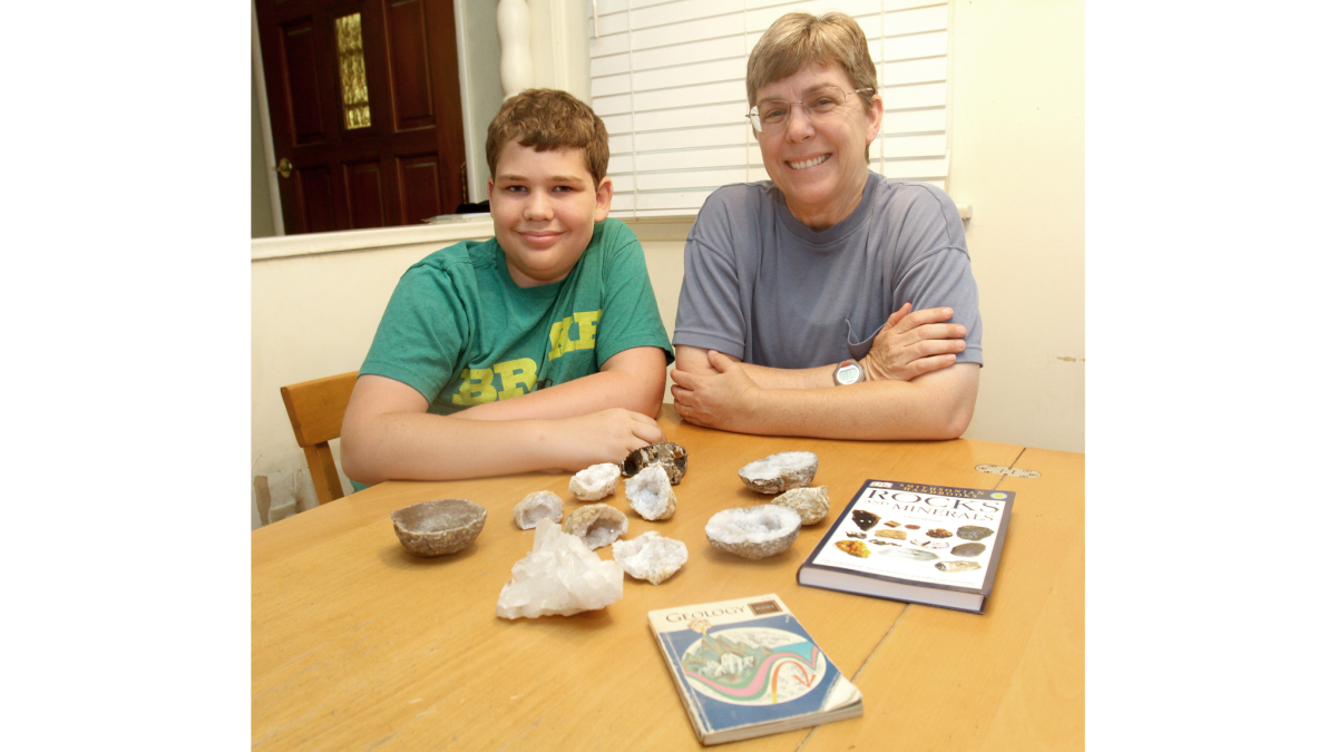 Kelly Duenckel, right, and her son Robert Duenckel, 13, at home showing some of the geodes he's collected along with some geology books.