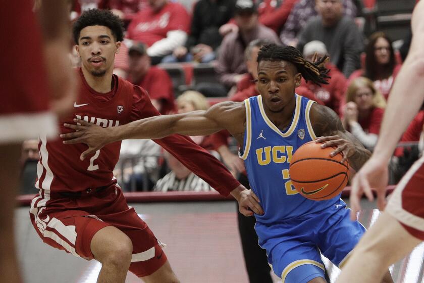 UCLA guard Dylan Andrews, right, drives while pressured by Washington State guard Myles Rice.