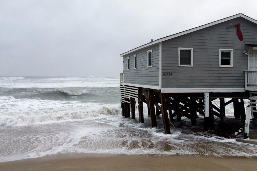 Waves wash ashore hitting a house as winds and storm surge from Tropical Storm Maria lash North Carolinas Outer Banks as the storm moves by well off-shore on Wednesday, Sept. 27, 2017. Dare County officials said the high tide flooded some roads in the area and travel is hazardous. (AP Photo/Ben Finley)