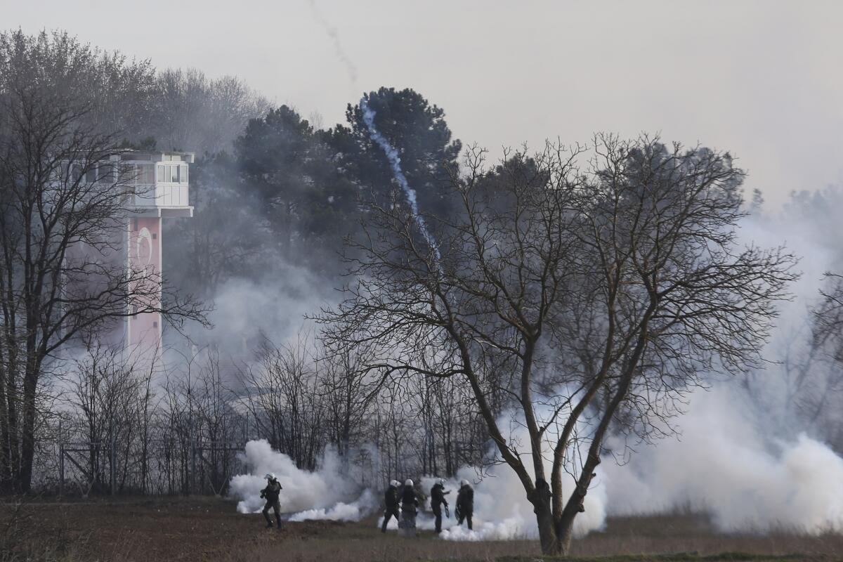 Tear gas rises along the Greek-Turkish border on Friday as Greek riot police clash with migrants.