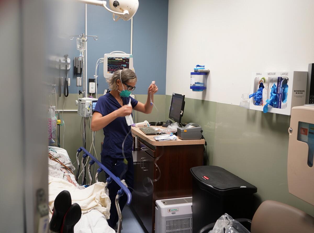 La enfermera Sandra Younan prepara una línea intravenosa para un paciente, 