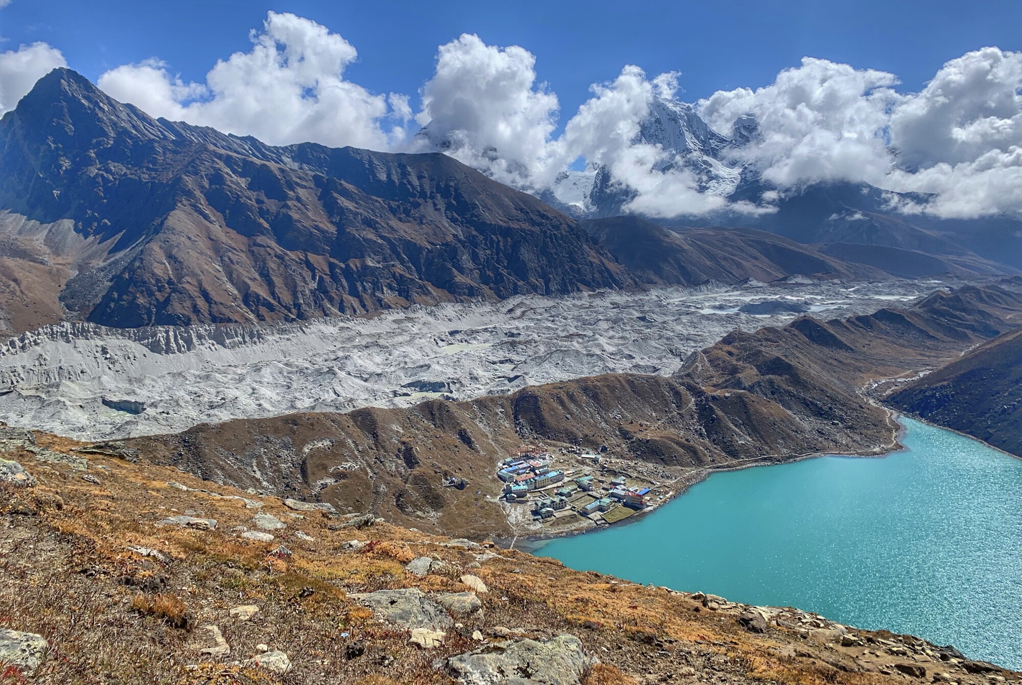 A view of a town on the edge of pristine lakes by a massive glacier (center). 