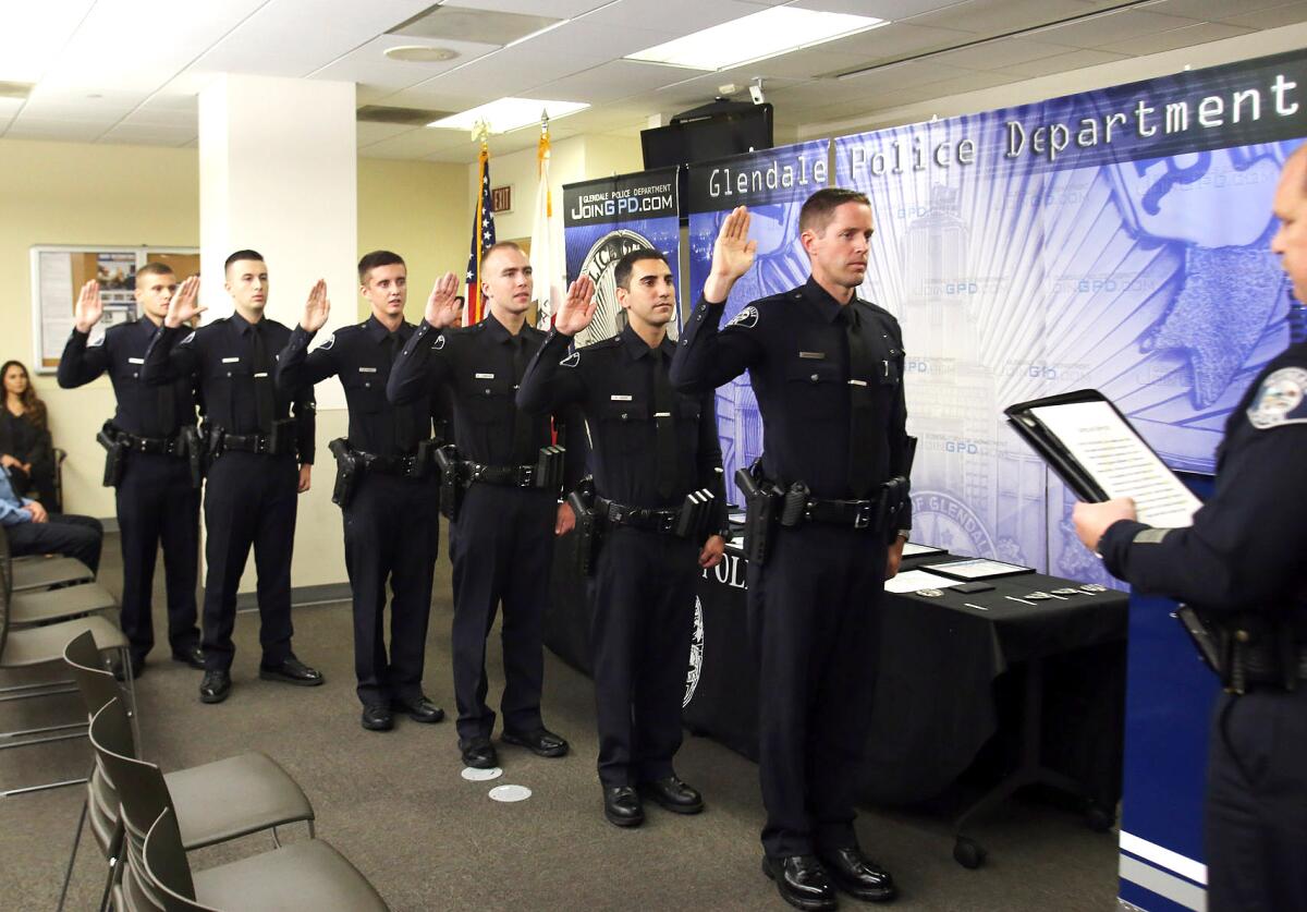 Glendale Police Chief Carl Povilaitis administers the oath of office to six new officers who joined the department during a promotion and swearing in ceremony on Thursday, Sept. 12, 2019. 