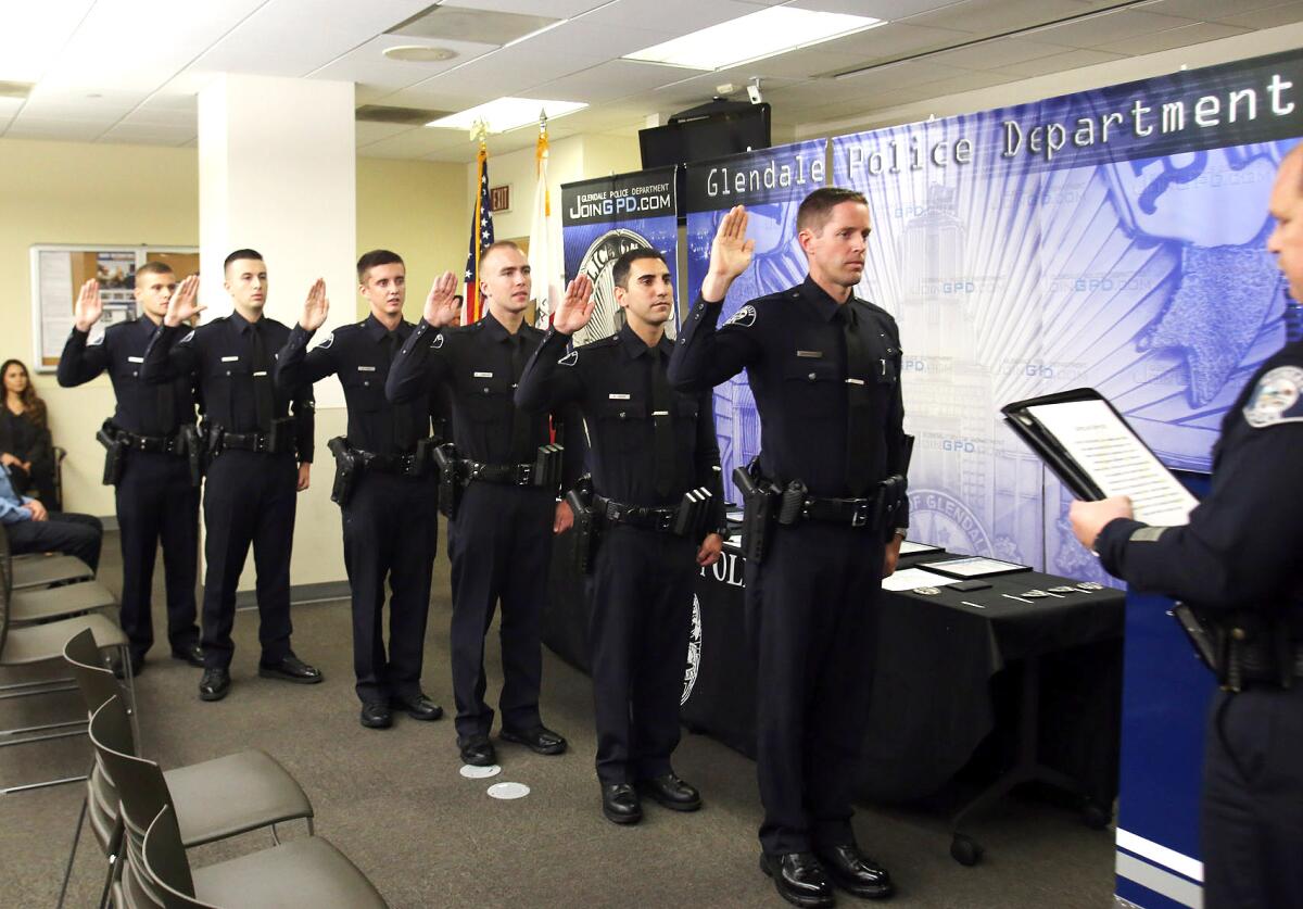 Glendale Police Chief Carl Povilaitis administers the oath of office to six new officers who joined the department during a promotion and swearing in ceremony on Thursday, Sept. 12, 2019.
