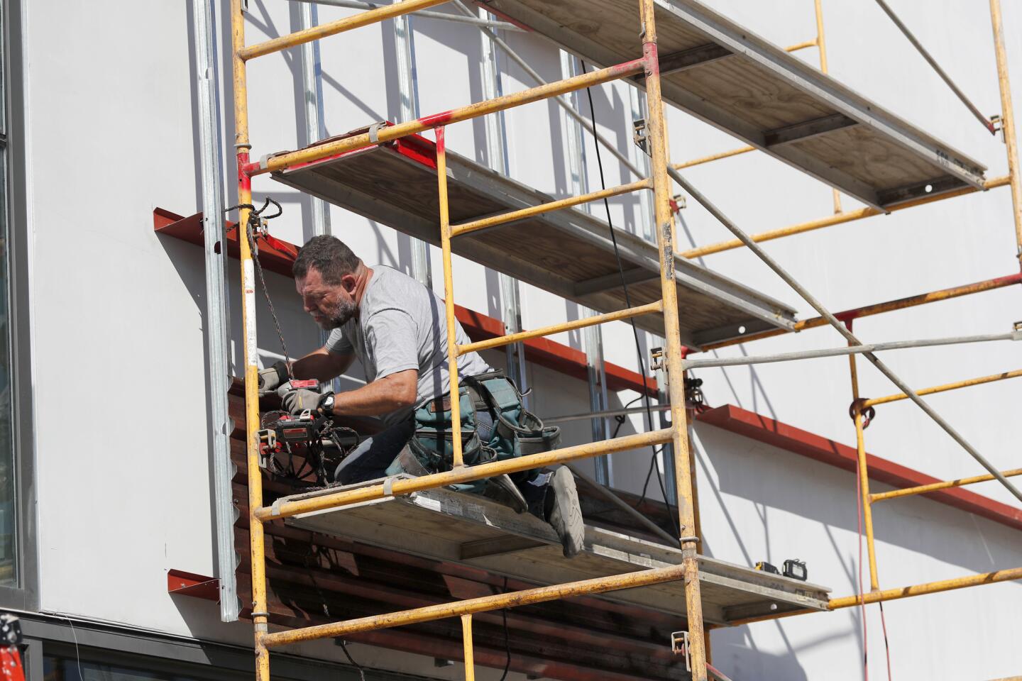 Marcos Ramirez "ERRE" works on his installation on the exterior of the Oceanside Museum of Art.