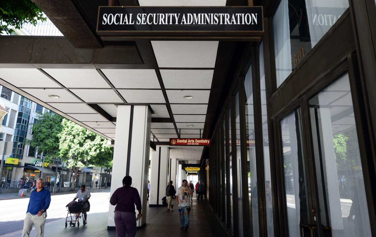 Pedestrians walk past the Social Security Administration office in downtown Los Angeles on Oct. 1, 2013.