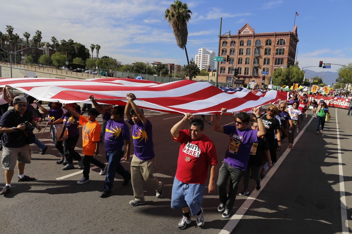 Marchers head across the 101 Freeway en route to Grand Park for a rally to promote immigrants' rights as part of a May Day rally.