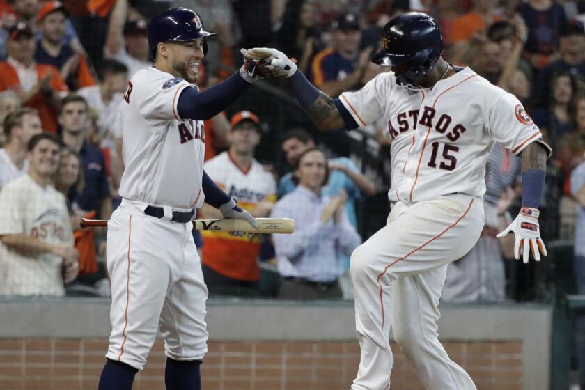 Houston Astros' Martin Maldonado (15) celebrates his solo home run against the Cleveland Indians with teammate George Springer, left, during the seventh inning in Game 1 of an American League Division Series baseball game Friday, Oct. 5, 2018, in Houston. (AP Photo/David J. Phillip)