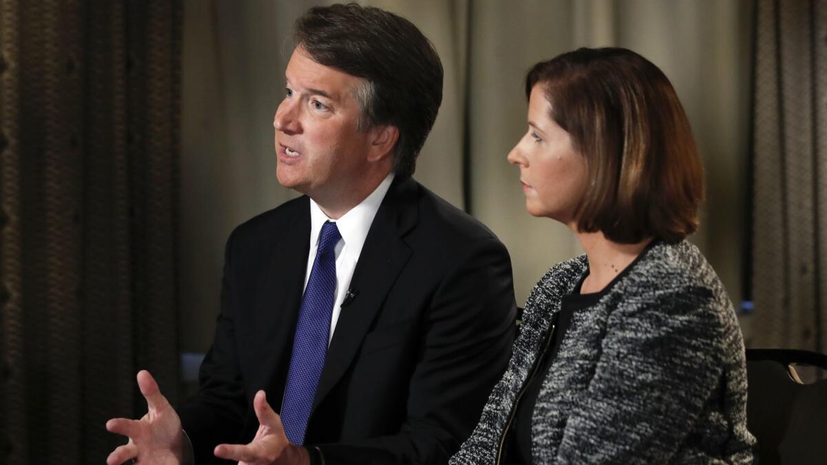 Brett Kavanaugh, with his wife, Ashley Estes Kavanaugh, answers questions during a Fox News interview on Sept. 24.