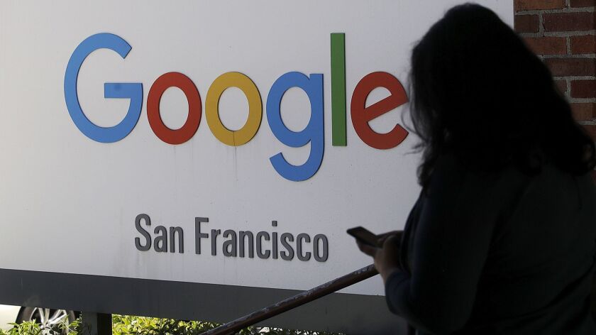 A woman walks past a Google sign in San Francisco in May.
