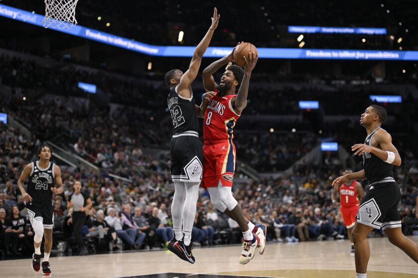 New Orleans Pelicans' Naji Marshall (8) shoots against San Antonio Spurs' Malaki Branham during the second half of an NBA basketball game, Friday, Dec. 2, 2022, in San Antonio. (AP Photo/Darren Abate)