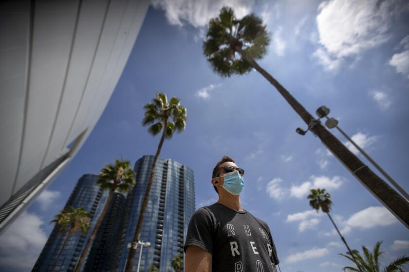 LOS ANGELES, CA - JUNE 18: Brandon Leslie, an RN working with COVID-19 patients at Good Samaritan Medical Center, wears a protective mask to help protect from contracting COVID-19, takes a walk by the Staples Center Thursday, June 18, 2020 in Los Angeles, CA. Gov. Gavin Newsom on Thursday ordered all Californians to wear face coverings while in public or high-risk settings, including when shopping, taking public transit or seeking medical care, following growing concerns that an increase in coronavirus cases has been caused by residents failing to voluntarily take that precaution. (Allen J. Schaben / Los Angeles Times)