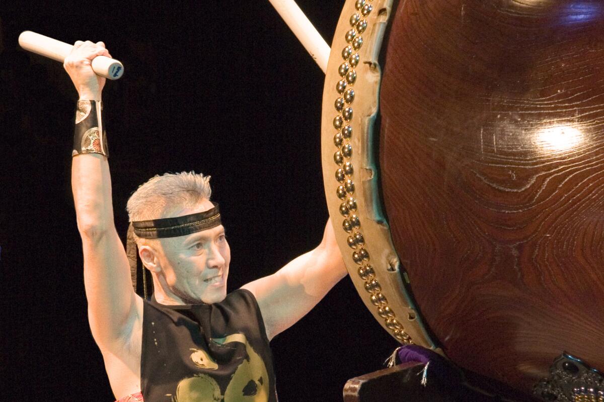 Kenny Endo pounds on a drum as tall as he is.