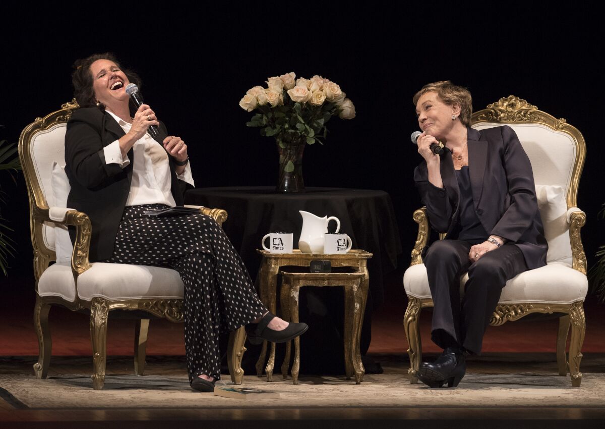 Times columnist Mary McNamara, left and laughing, seated onstage at the Orpheum with Julie Andrews, both holding microphones.