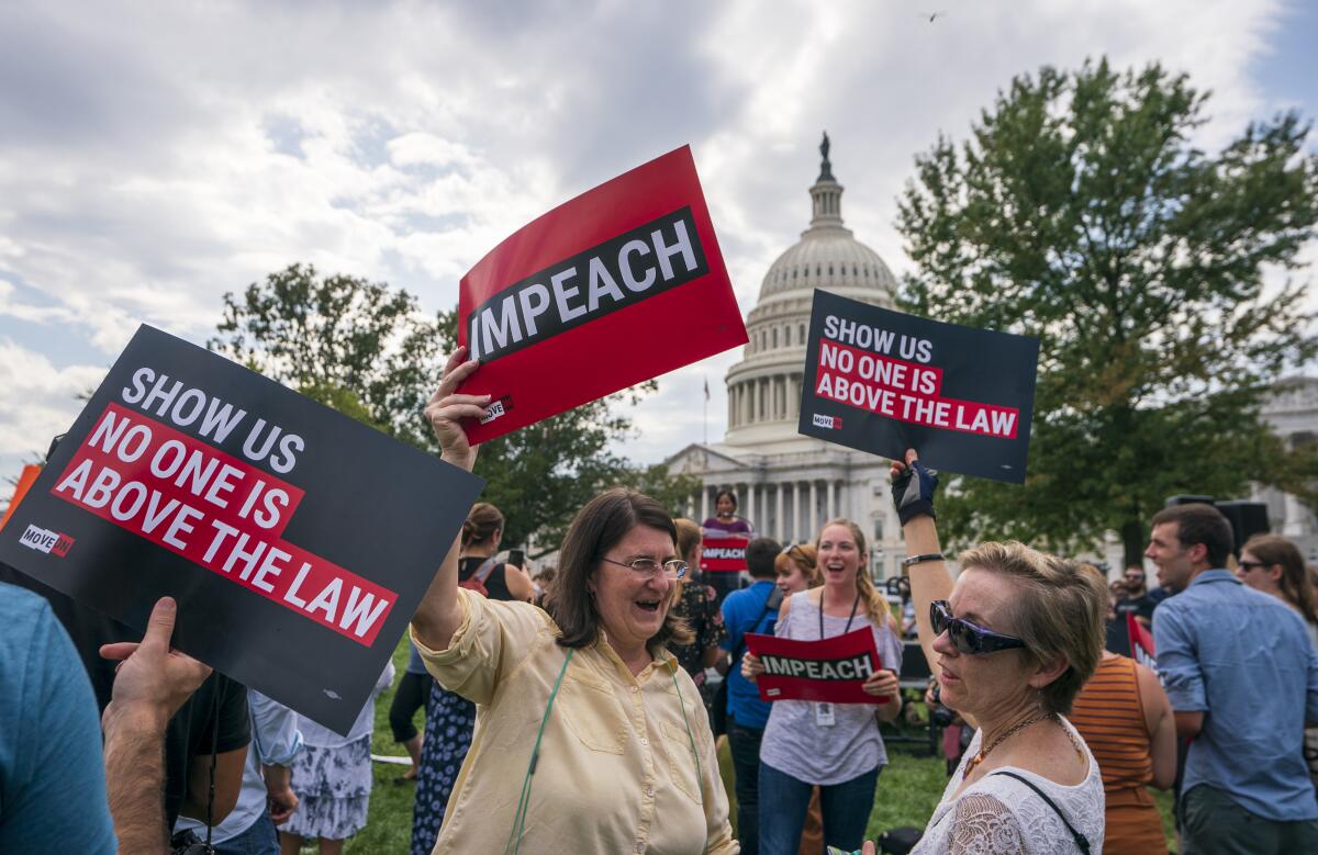 Activistas se manifiestan por la acusación del presidente Trump el jueves en el Capitolio de Washington.