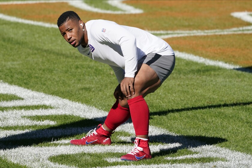 FILE - New York Giants running back Saquon Barkley warms up before an NFL football game against the Chicago Bears in Chicago, in this Sunday, Sept. 20, 2020, file photo. Saquon Barkley says his surgically repaired knee is doing well, though the New York Giants star running back won’t set a target date for his return. Barkley, the 2018 NFL Offensive Rookie of the Year, tore his right ACL in Week 2 and missed the rest of the 2020 season. (AP Photo/Charles Rex Arbogast)