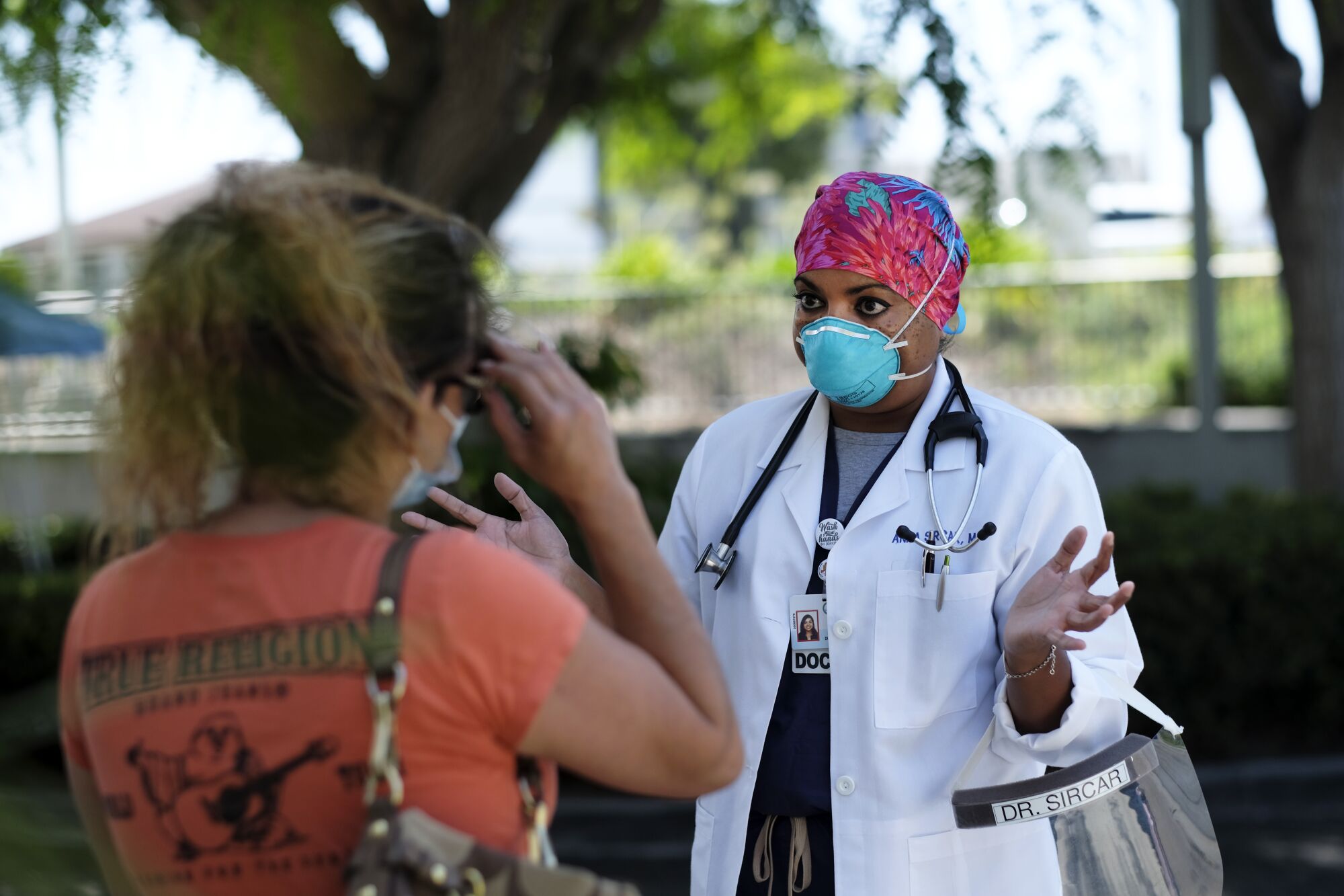 A doctor talks to a woman outside