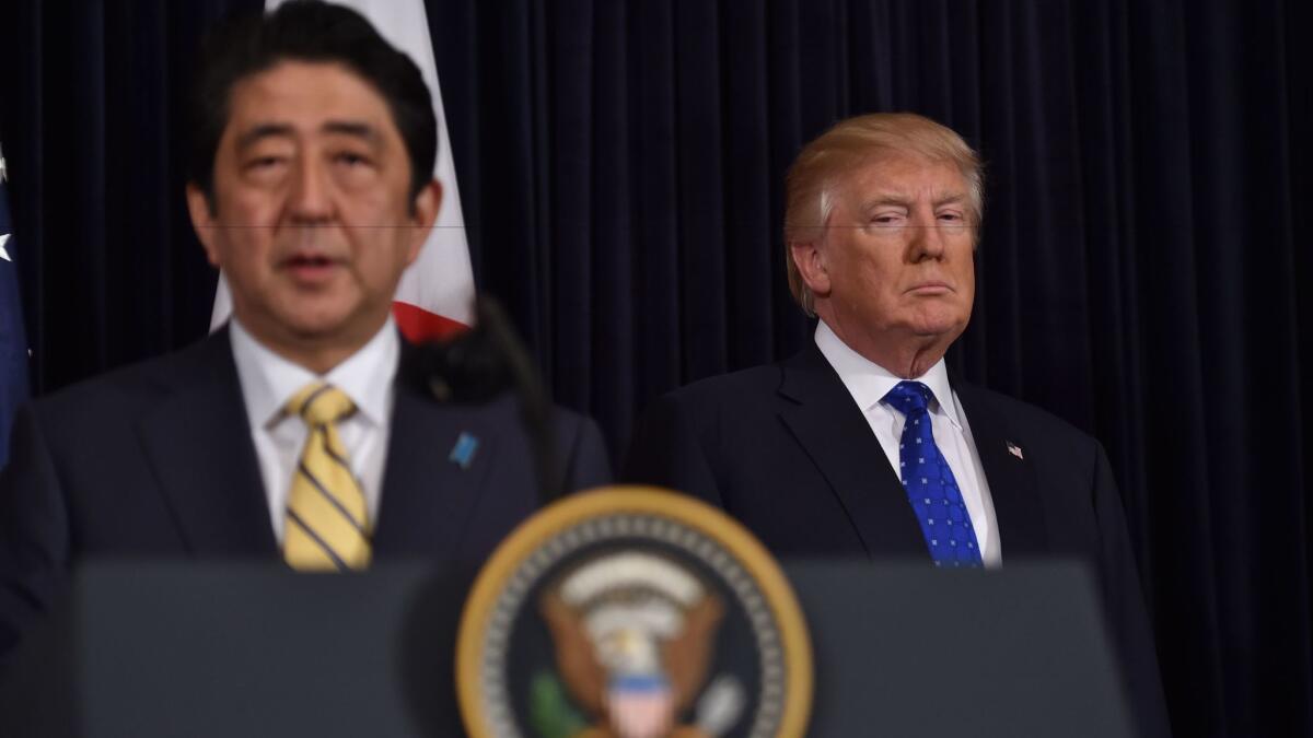 周六，在特朗普位于佛罗里达州棕榈滩的度假村中，日本首相安倍晋三发表讲话，总统特朗普在旁边听。