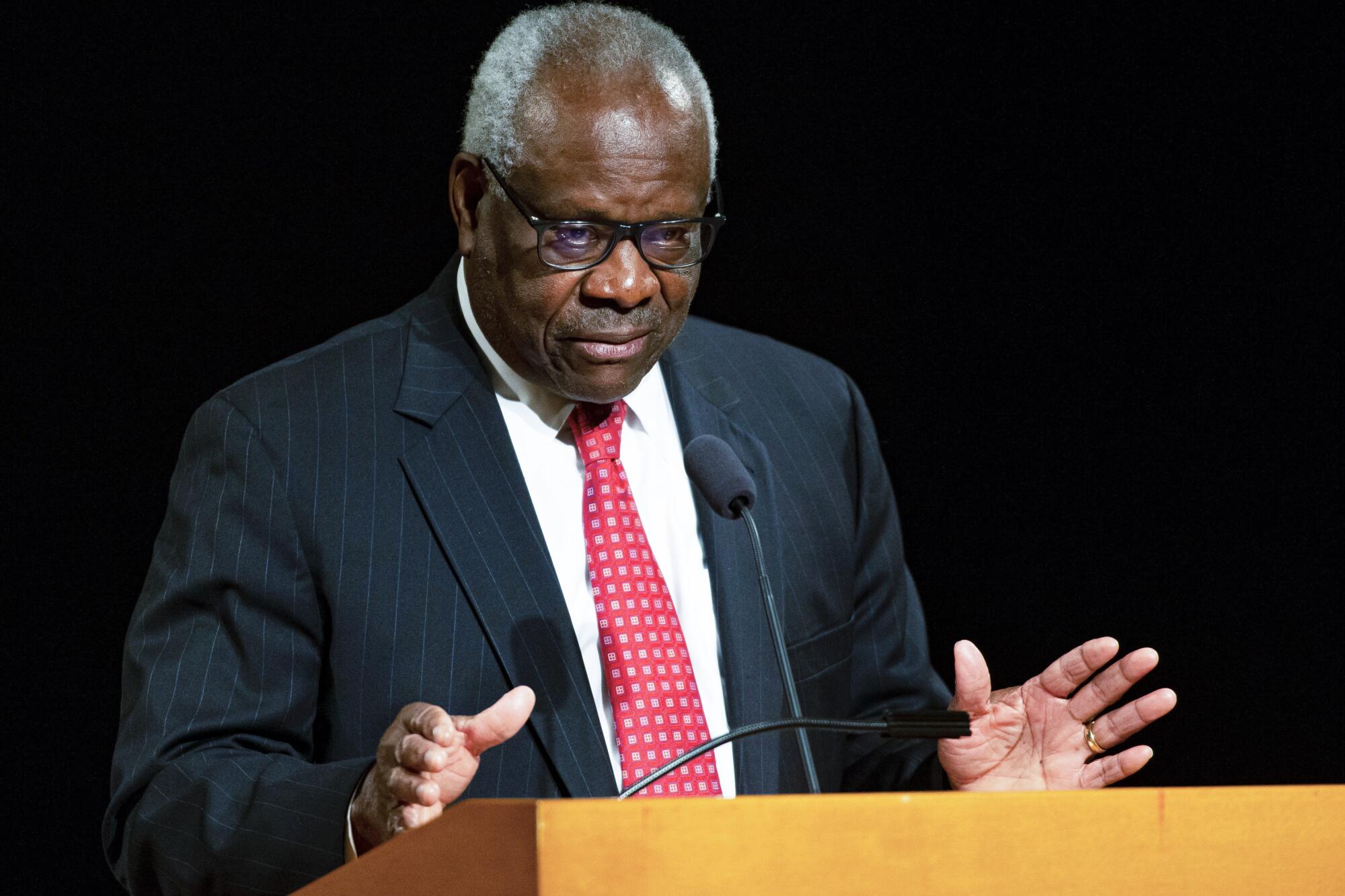  Supreme Court Justice Clarence Thomas gesturing as he speaks from a lectern