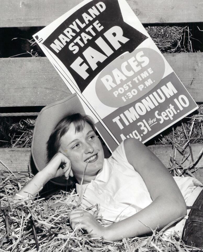 Phyllis Dillow of Upperco in front of a poster advertising the 1955 fair.