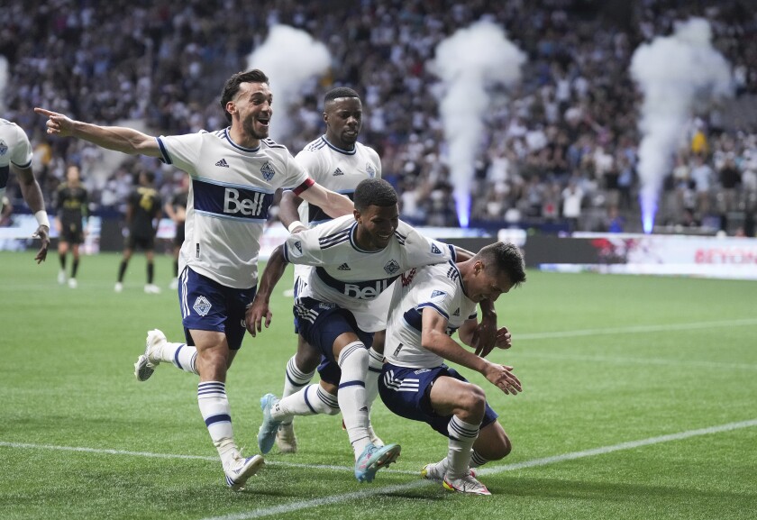 Vancouver Whitecaps' Russell Teibert, Pedro Vite and Andres Cubas, from left in front, and Cristian Dajome, back, celebrate Cubas' goal against Los Angeles FC during the second half of an MLS soccer match Saturday, July 2, 2022, in Vancouver, British Columbia. (Darryl Dyck/The Canadian Press via AP)