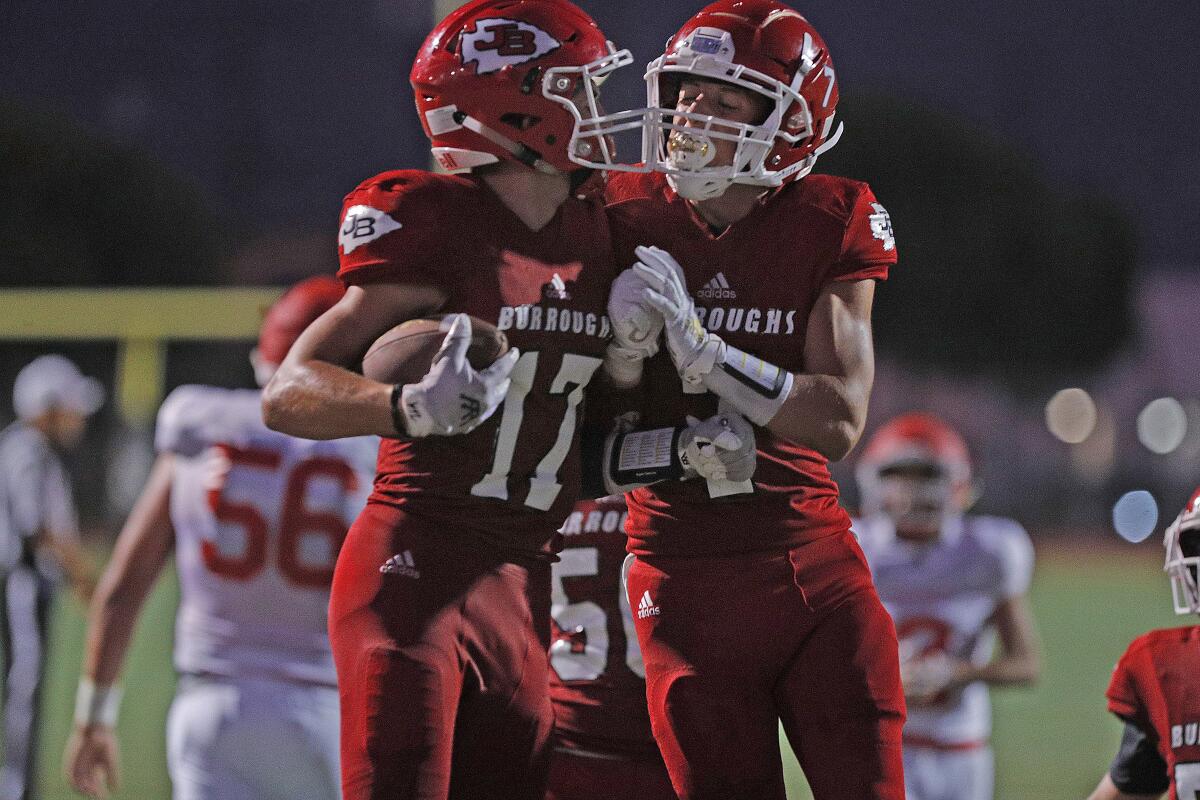 Burroughs' Aiden Forrester jumps with Burroughs' Carson Cardenaz to celebrate a long touchdown run against Hueneme in a season opening non-league football game at Memorial Field in Burbank on Thursday, August 22, 2019.
