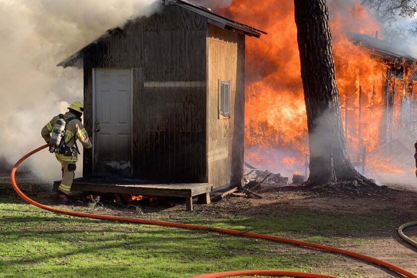 Firefighters responded to a house fire that spread to an outbuilding and a tree in Jamul on Sunday afternoon. 