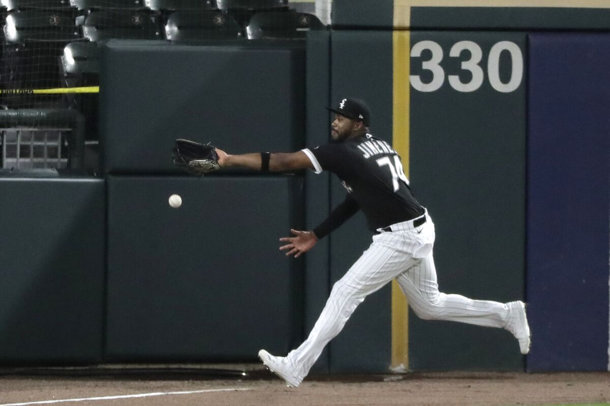 Chicago White Sox left fielder Eloy Jimenez can't make the play on an inside-the-park home run by Milwaukee Brewers' Christian Yelich during the fifth inning of a baseball game in Chicago, Thursday, Aug. 6, 2020. (AP Photo/Nam Y. Huh)