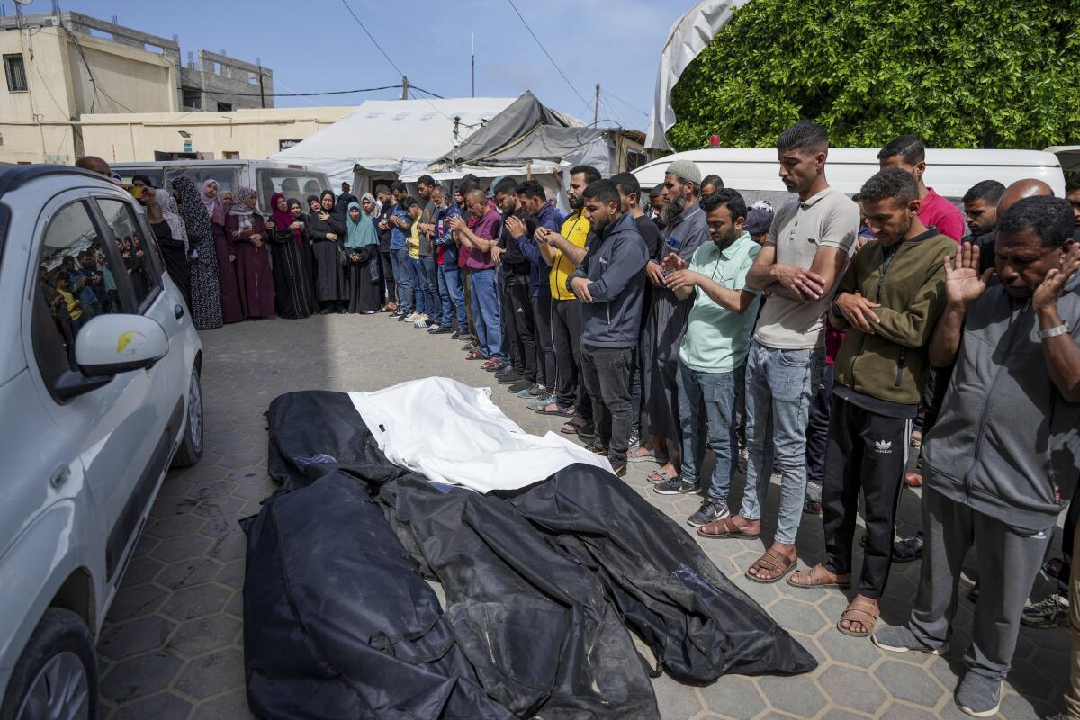 Mourners pray over the bodies of Palestinians killed in an Israeli airstrike.