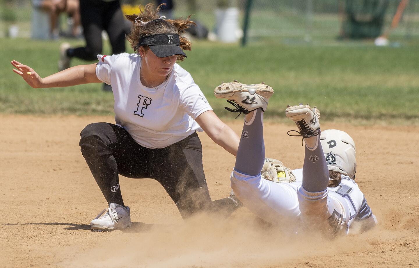 Lakewood Firecrackers's Izzy Pena tags out Texas Bombers's Lourdes Bacon in a 16U Premier softball game in the PGF Nationals in Fountain Valley on Wednesday, August 1.