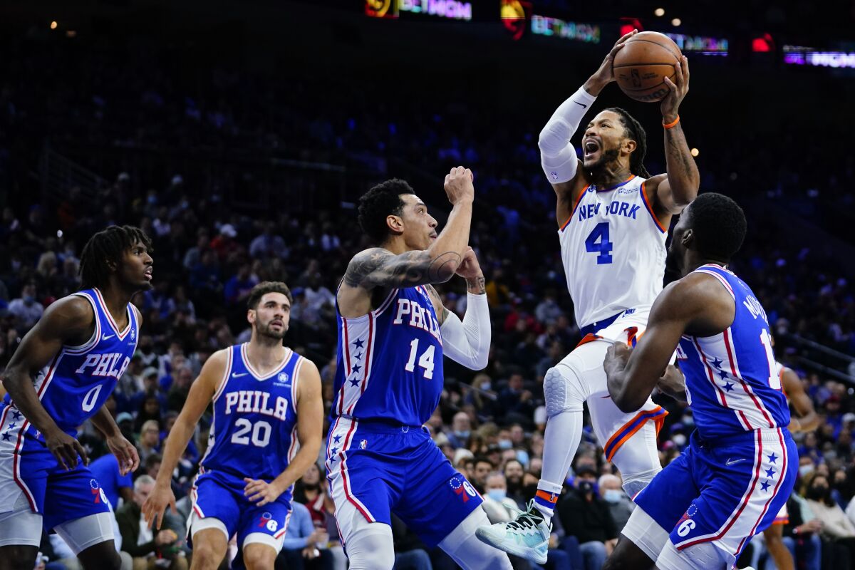 New York Knicks' Derrick Rose (4) goes up for a shot against Philadelphia 76ers' Shake Milton, from right, Danny Green, Georges Niang and Tyrese Maxey during the first half of an NBA basketball game, Monday, Nov. 8, 2021, in Philadelphia. (AP Photo/Matt Slocum)