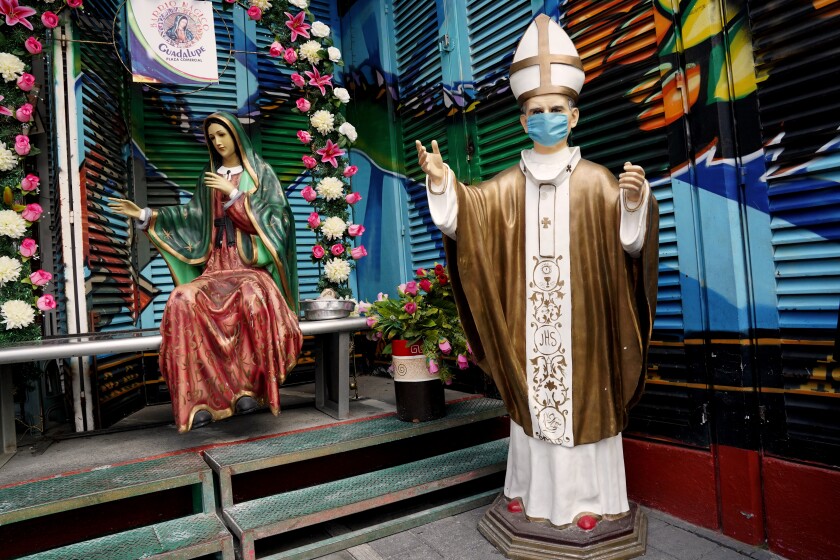 Shops near the basilica selling religious items and figures, some with masks, were shut down or had few customers.