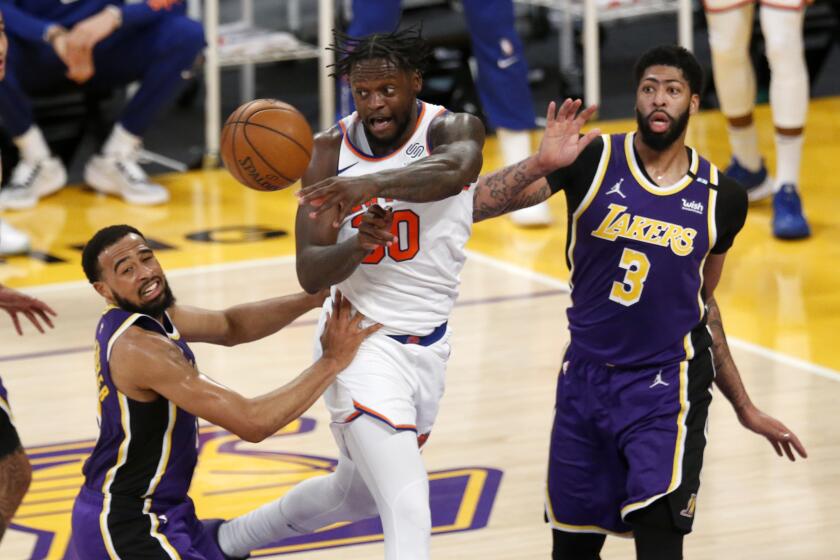 Knicks' Julius Randle makes a pass while defended by the Lakers' Talen Horton-Tucker and Anthony Davis (3) on May 11, 2021.