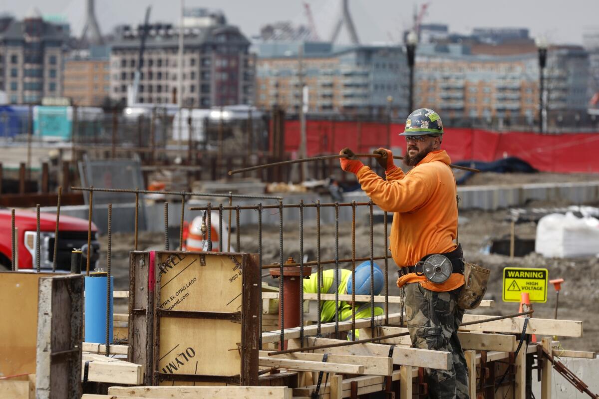 Un trabajador de la construcción prepara un cimiento de concreto, 17 de marzo de 2023, en Boston. 
