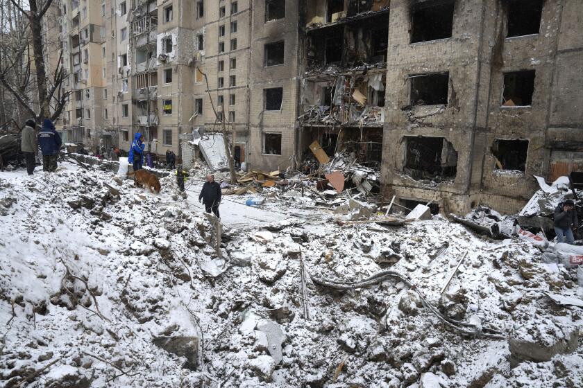 A crater of an explosion is seen next to an apartment building destroyed after Tuesday's Russian attack in Kyiv, Ukraine, Wednesday, Jan. 3, 2024. (AP Photo/Efrem Lukatsky)