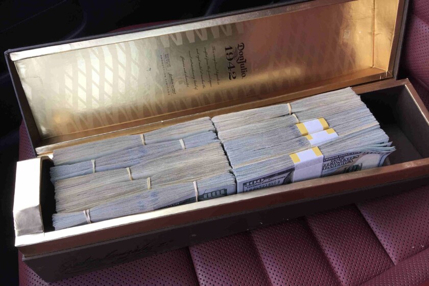 Bundles of money in a liquor case.