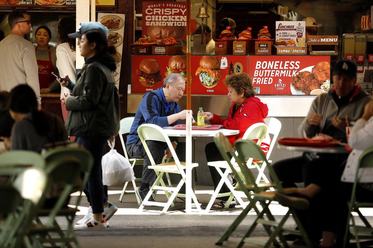 Visitors sitting and eating at the Original Farmers Market
