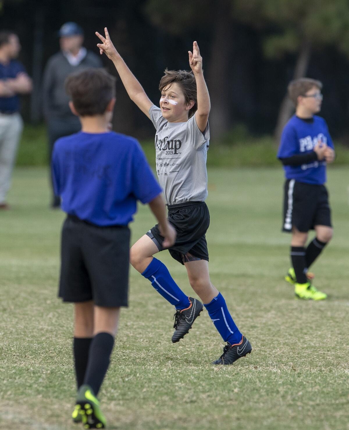 Our Lady Queen of Angels Catholic School's Travis Reedy celebrates after scoring a goal against Carden Hall in a boys' third- and fourth-grade Silver Division pool-play match at the Daily Pilot Cup on Thursday.