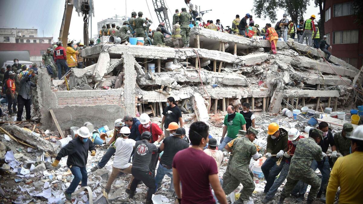Rescuers, firefighters, police, soldiers and volunteers search for survivors in a flattened building in Mexico City on Sept. 20, 2017, a day after a strong quake hit central Mexico.