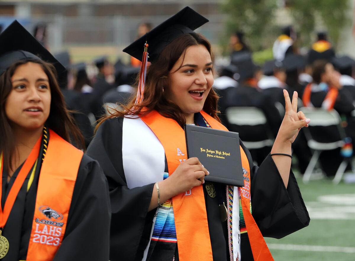 Graduate Daniarely Juarez flashes the peace symbol.