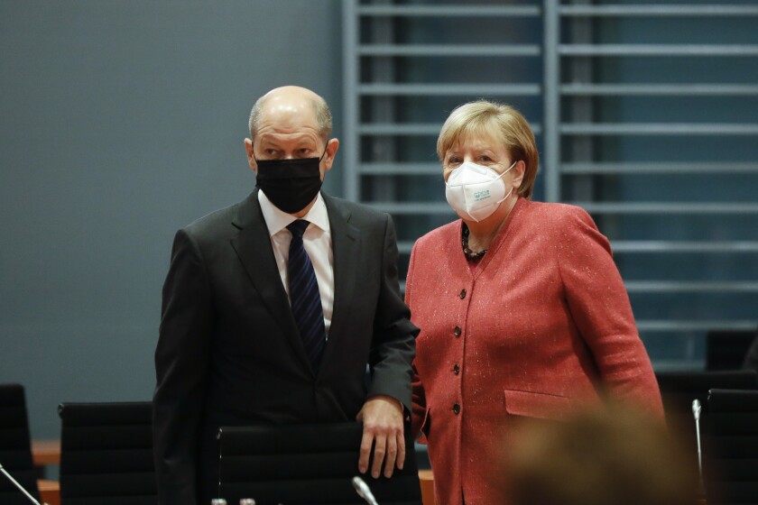 FILE - In this Nov. 11, 2020 file photo, German Chancellor Angela Merkel, right, and German Finance Minister Olaf Scholz arrive at the weekly cabinet meeting of the German government at the chancellery in Berlin, Germany. German lawmakers say they plan to question Chancellor Angela Merkel and her deputy about their involvement with the collapsed payment systems provider Wirecard next month. (AP Photo/Markus Schreiber, File)