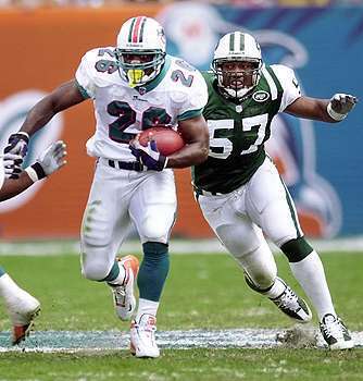 Dolphins RB Lamar Smith finds some running room as New York Jets' Mo Lewis gives chase in the first half of Sunday's game at Pro Player Stadium.